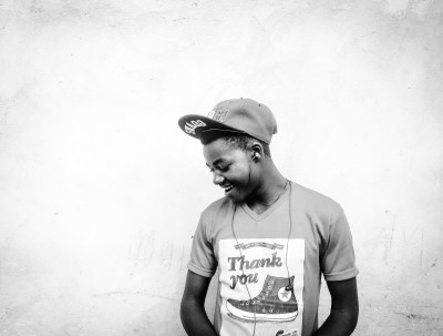 Young person listening to earphones on white backdrop