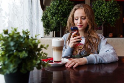 girl on phone while at a coffee shop